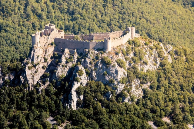 Le château de Puilaurens : son imposante silhouette crénelée a ainsi gardé toute sa hauteur, surgissant à 697 m d’altitude au sommet d’une crête abrupte, au-dessus des forêts ondulantes de la vallée de la Boulzane.