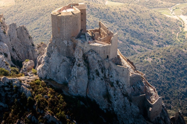 Véritable nid d’aigle dressé à 728 m d’altitude sur un piton rocheux à l’extrême sud des Hautes-Corbières, le château de Quéribus veille depuis des siècles sur la vaste plaine du Roussillon.